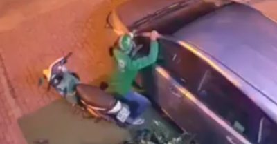 Người đàn ông mặc đồng phục xe ôm công nghệ dùng vai bẻ gương ôtô ở TP. HCM