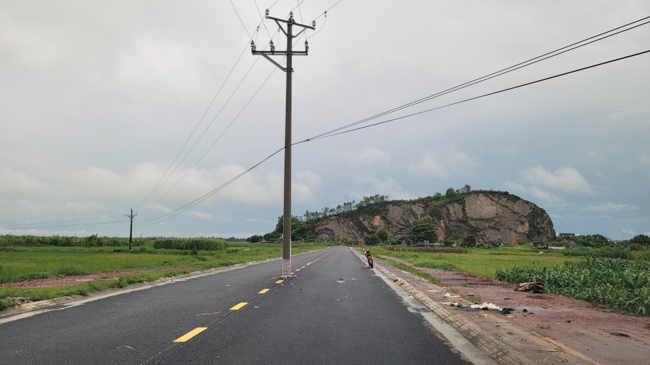 Hàng cột điện trung thế nằm giữa đường ở xã Hoằng Kim, nơi vụ tai nạn chết người mới xảy ra. Ảnh: Lam Sơn