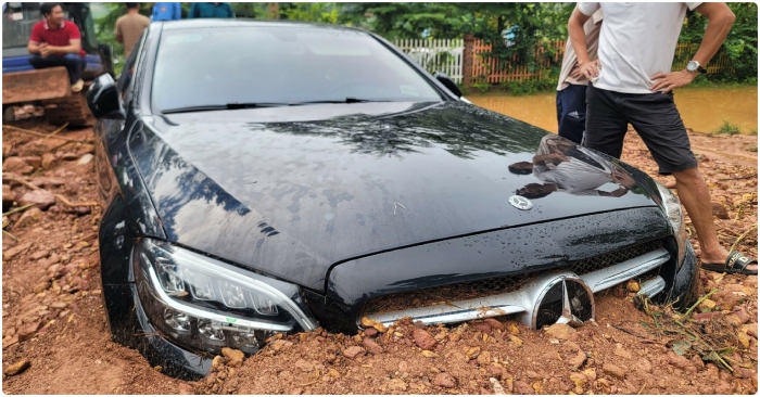 Một chiếc Mercedes-Benz bị vùi lấp tới nửa thân xe đang chờ giải cứu.